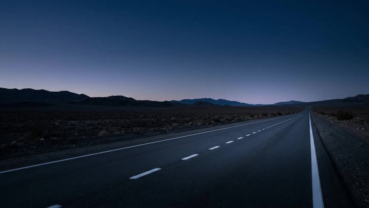 An empty desert road at dusk